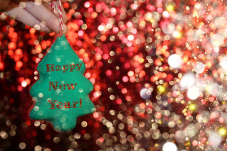 beautiful Christmas tree is lying on his hands, on a shiny backgroundの写真素材
