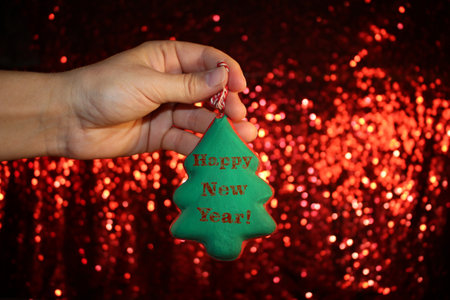 beautiful Christmas tree is lying on his hands, on a shiny backgroundの写真素材