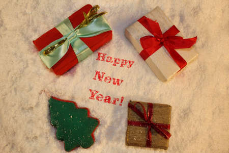 beautiful green Christmas tree and a gift lies on the white snowの写真素材