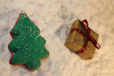 beautiful green Christmas tree and a gift lies on the white snowの写真素材