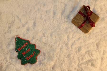 beautiful green Christmas tree and a gift lies on the white snowの写真素材