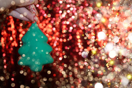 beautiful green Christmas tree is lying on your hand on a shiny backgroundの写真素材