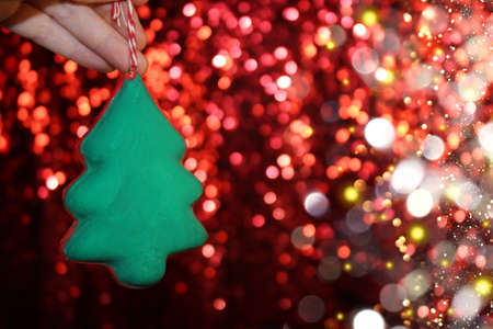 beautiful green Christmas tree is lying on your hand on a shiny backgroundの写真素材