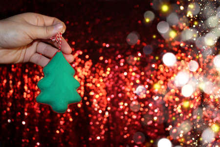 beautiful green Christmas tree is lying on your hand on a shiny backgroundの写真素材