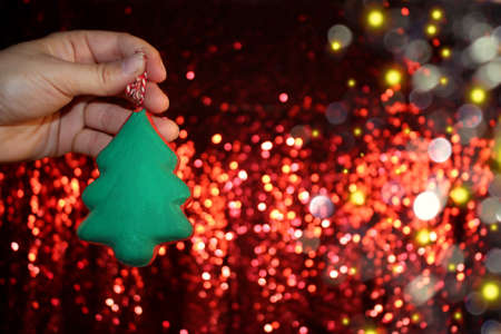 beautiful green Christmas tree is lying on your hand on a shiny backgroundの写真素材