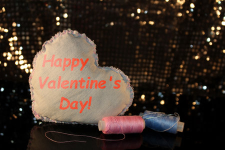 beautiful heart made of denim fabric on a shiny backgroundの写真素材