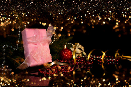 Christmas background with a green fir tree, a gift and candy on a shiny background in the video it is snowingの写真素材
