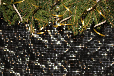 Christmas background with green spruce and confetti on a shiny background
