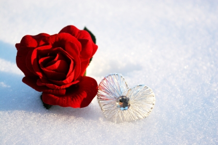 beatiful red rose in snow with crystal heart in a winter day の写真素材