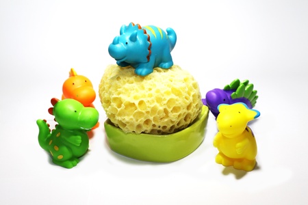 funny colored plastic dinosaurs for bathing babies with spongeの写真素材