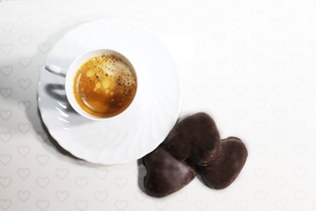 a cup of coffee on a tray with some chocolate treatsの写真素材