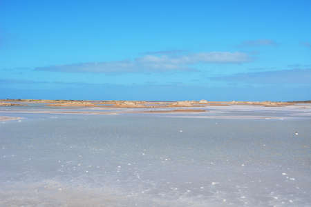 The blue and white colors of the Porto Ingles salt pans in a sunny dayの写真素材