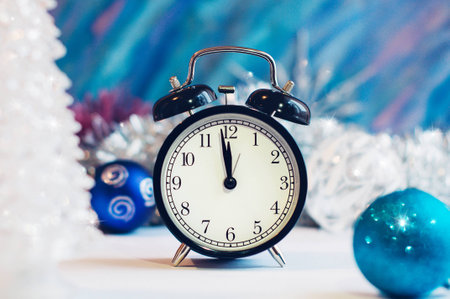 New Year alarm clock on a silver and blue background. New Year and Christmas decoration. Midnight.の写真素材
