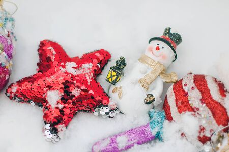 Colofrul christmas and new year toys lying on snow. Festive background.