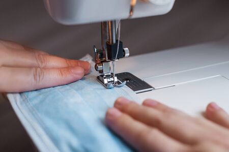 Sewing the medical mask on a sewing machine at home.の写真素材