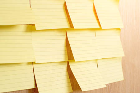 Yellow blank pieces of paper on a wooden texture background Empty copy spaceの写真素材