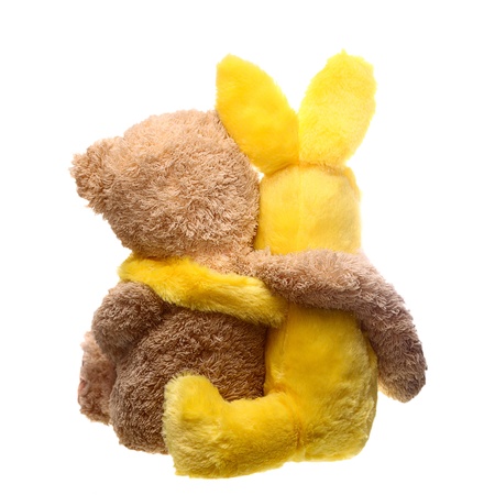 Back view of two toys hugging each other over whiteの写真素材