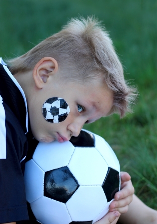 A young boy with painted face and soccer ball の写真素材