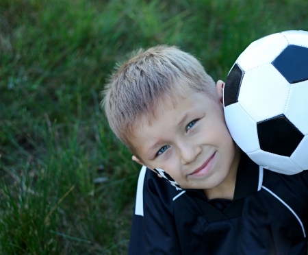 A young boy with painted face and soccer ball の写真素材