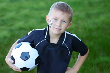 A young boy with painted face and soccer ball の写真素材