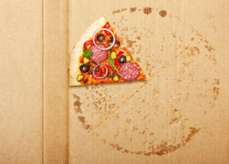 Salami pizza slice over box.