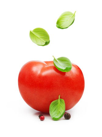 Red tomato and basil leaves spice falling down isolated on white background.の写真素材