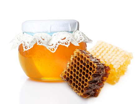 Glass bowl with honey and slice honey comb isolated on white backgroundの写真素材