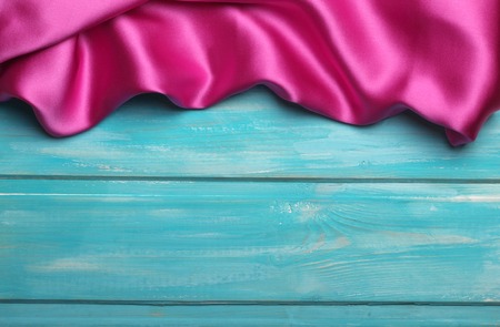 Purple wavy silk on blue wooden background.の写真素材