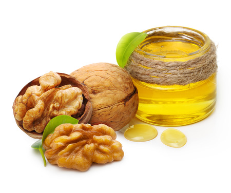 Walnut oil and nuts with leaf isolated on white backgroundの写真素材