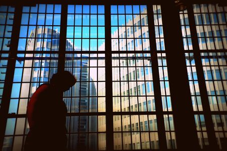 Person in silhouette with buildings in the backgroundの写真素材