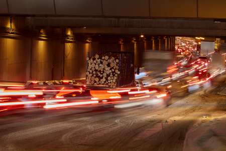 Tunnel at night. From the fast-moving cars are a beautiful trail. Only the truck with the timber stop.の写真素材