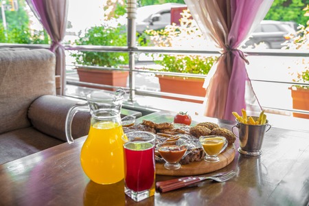 Grilled beef steak and Assorted delicious grilled meat with and cool drinks on the table of the summer verandaの写真素材