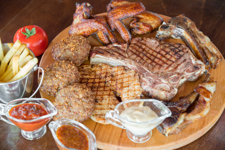 Grilled beef steak and Assorted delicious grilled meat on wooden boardの写真素材
