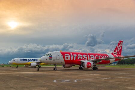 Low cost airlines Cebu Pacific and Air Asia aircraft at colorful sunset at Puerta Princesa Airport in Palawan island, Philippines. August 2018.のeditorial素材