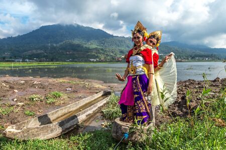 Portrait of Two Young Balinese traditional girls on the lake in the old boat in Bali, Indonesia. June 2018のeditorial素材