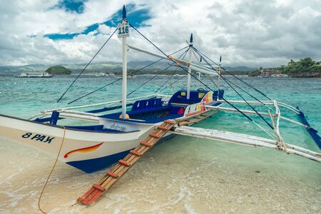 Filipino boats in the azure sea in Boracay at clouds day, Philippines. August 2016のeditorial素材