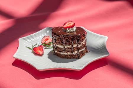 Whoopie pie cake on plate with strawberry slices on abstract pink silk fabric background.の写真素材