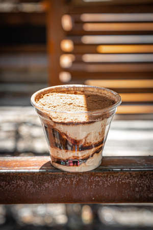 Tiramisu, traditional Italian dessert in a glass with chocolate on abstract background.の写真素材