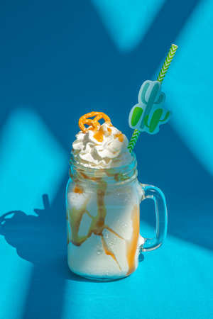 Banana milkshakes with caramel sauce and cookie on vivid blue background.の写真素材