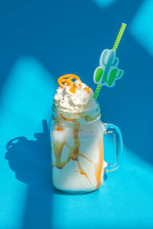 Banana milkshakes with caramel sauce and cookie on vivid blue background.の写真素材