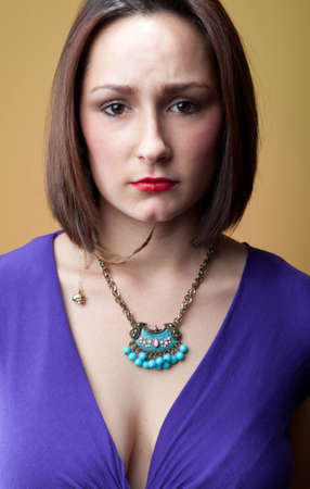 A young woman furrows her brow in an expression of worry and concern. の写真素材