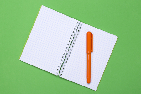 Open notebook and pen on a green backgroundの写真素材