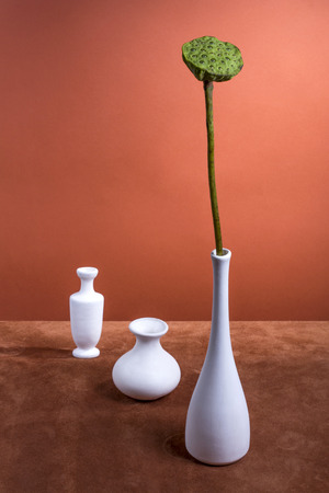 Still life with a lotus flower without petals and white vasesの写真素材