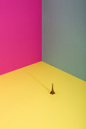 Abstract background of sheets of colored paper with a small figure of the Eiffel Towerの写真素材
