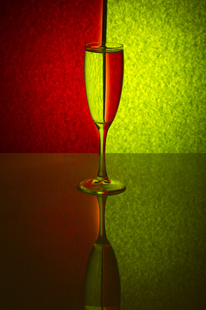 Still life with a transparent glass on a red-green backgroundの写真素材