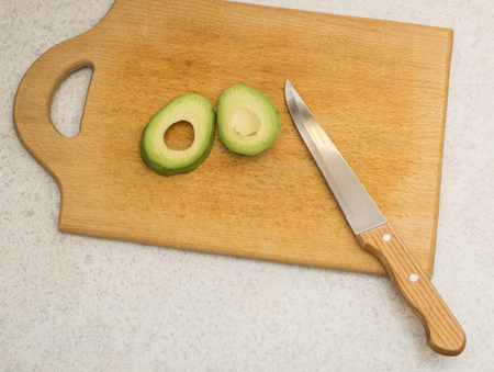 Cutting a ripe fruit avocado on a kitchen boardの写真素材