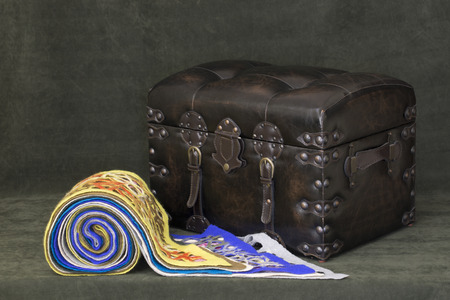 Women's woolen scarves are stacked on a leather chest