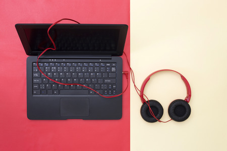 Laptop and connected headphones on a colored background, top viewの写真素材