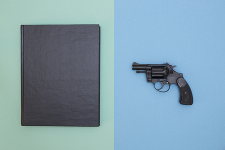 A book and a gun on a colored backgroundの写真素材