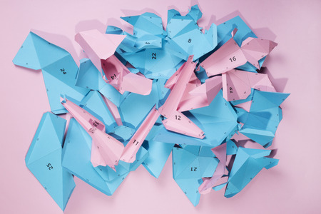 Details and parts of the papercraft scheme for assembling paper or cardboard figures on a pink backgroundの写真素材